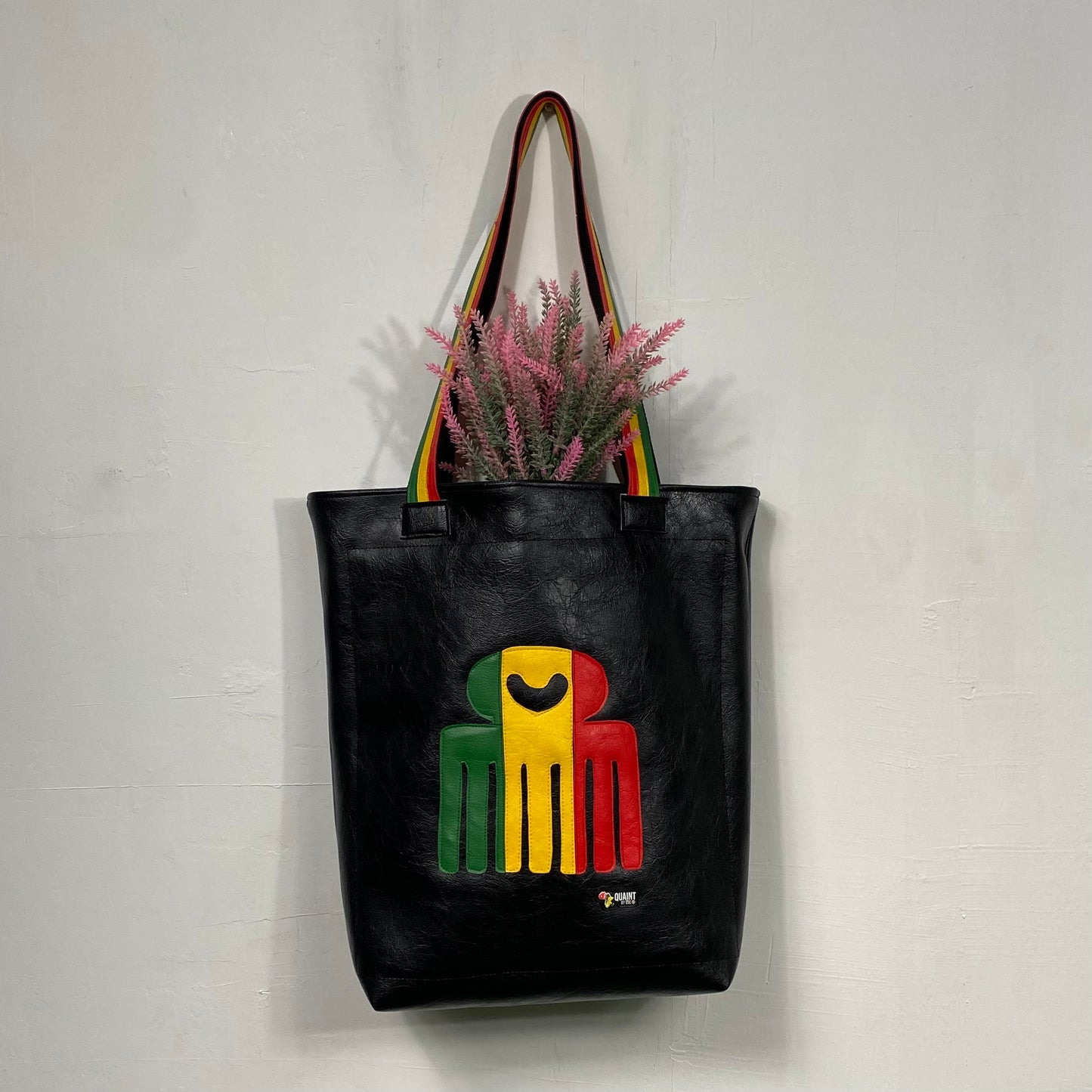 black leatherette tote bag with duafe adinkra symbol in rasta colors handmade in jamaica. laptop compartment, long straps and padded body.