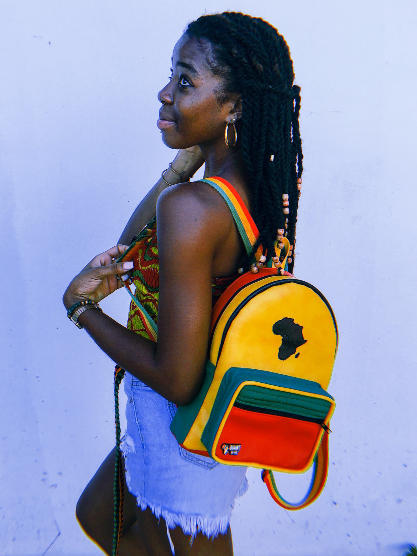 Ras'Pack - yellow backpack with red and green front pocket and a mapt of Africa.